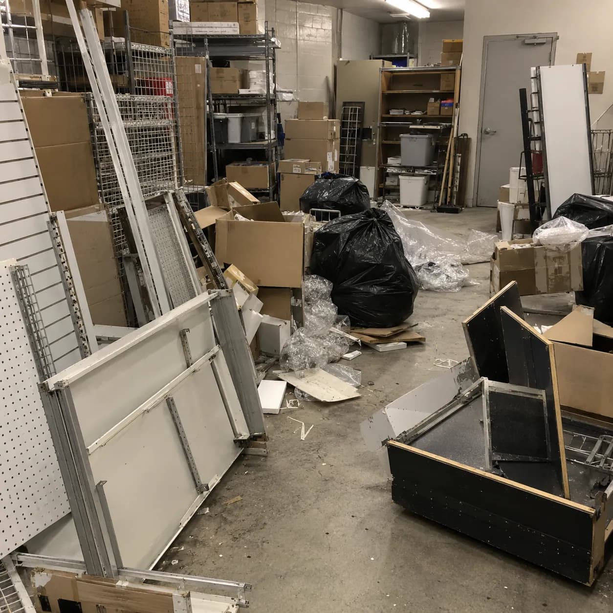 Retail shelving, slatwall panels and display fixtures stacked in an empty commercial unit